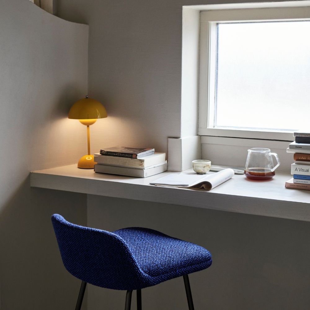 https://www.paletteandparlor.com/cdn/shop/files/and-tradition-vp9-flowerpot-portable-table-lamp-mustard-yellow-at-desk-with-blue-counter-stool_1000x.jpg?v=1684113572