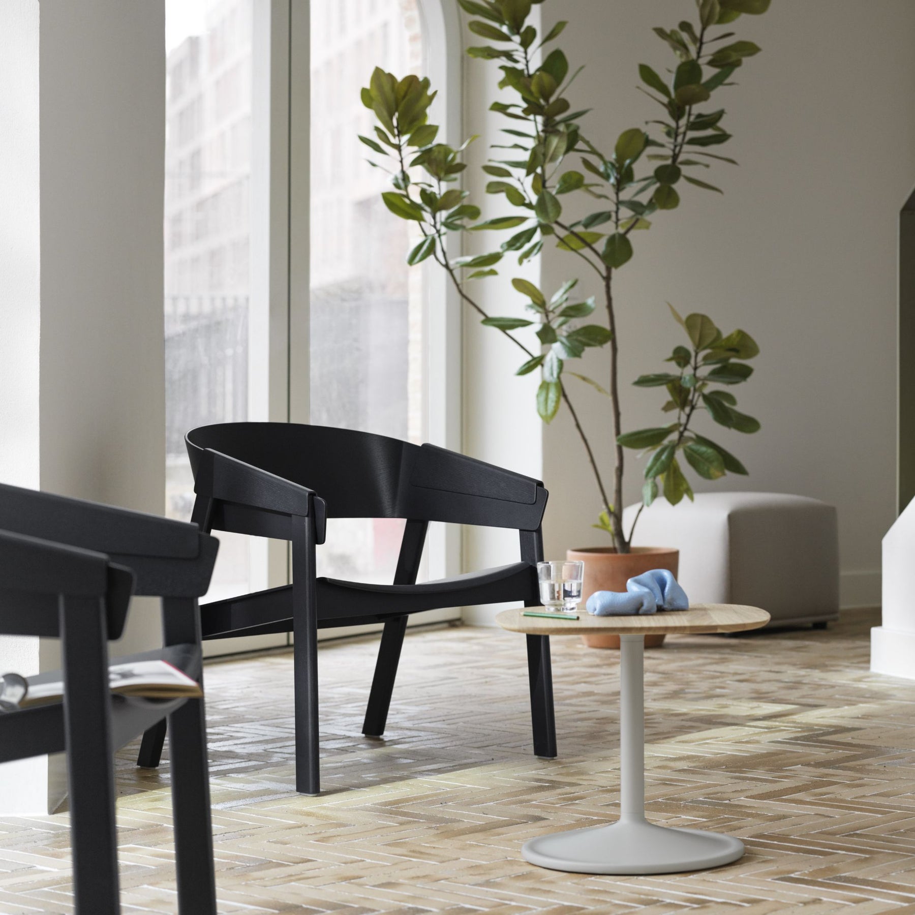 Muuto Soft Side Table Smoked Oak Top Black Base in Copenhagen Studio with Cover Lounge Chairs and Plant